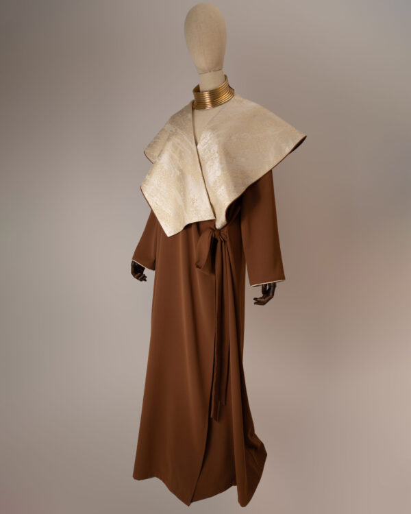 "Desert Radiance Abaya in light caramel with a shimmering golden shawl collar, featuring a flowing silhouette for elegance and comfort."