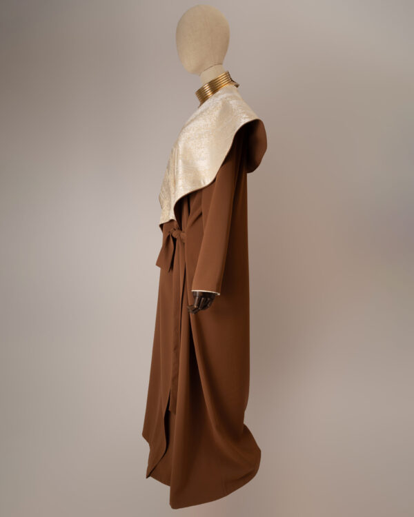 "Desert Radiance Abaya in light caramel with a shimmering golden shawl collar, featuring a flowing silhouette for elegance and comfort."