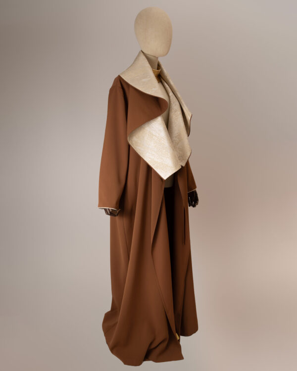 "Desert Radiance Abaya in light caramel with a shimmering golden shawl collar, featuring a flowing silhouette for elegance and comfort."