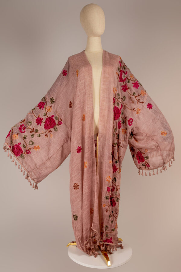 "Floral Enchantment Abaya featuring vibrant pink and orange floral embroidery on soft fabric with tassel accents, designed for elegance and comfort."